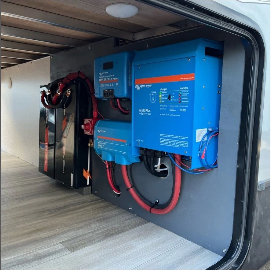 Inverter, solar charge controller, and lithium batteries installed in an RV storage bay