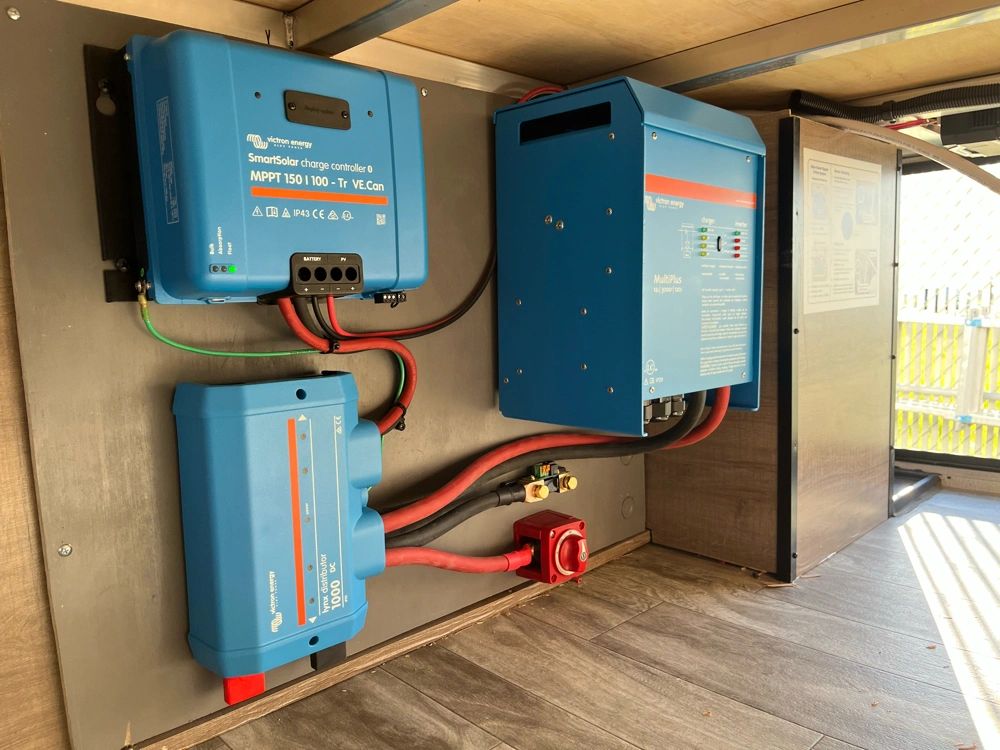 Close view of a Victron solar charge controller, inverter, and electrical distribution equipment